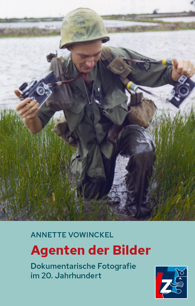 Ein Soldat in grüner Uniform und Helm kniet im Wasser und hält zwei Kameras. Hohes Gras umgibt ihn. Der Text auf dem Buchdeckel lautet: "Agenten der Bilder: Dokumentarische Fotografie im 20. Jahrhundert" von Annette Vowinckel.