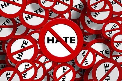 Mehrere rote "No hate"-Symbole überlagern sich und zeigen das Wort "HATE" hinter einem roten Verbotsschild, das eine Anti-Hass-Botschaft vermittelt.