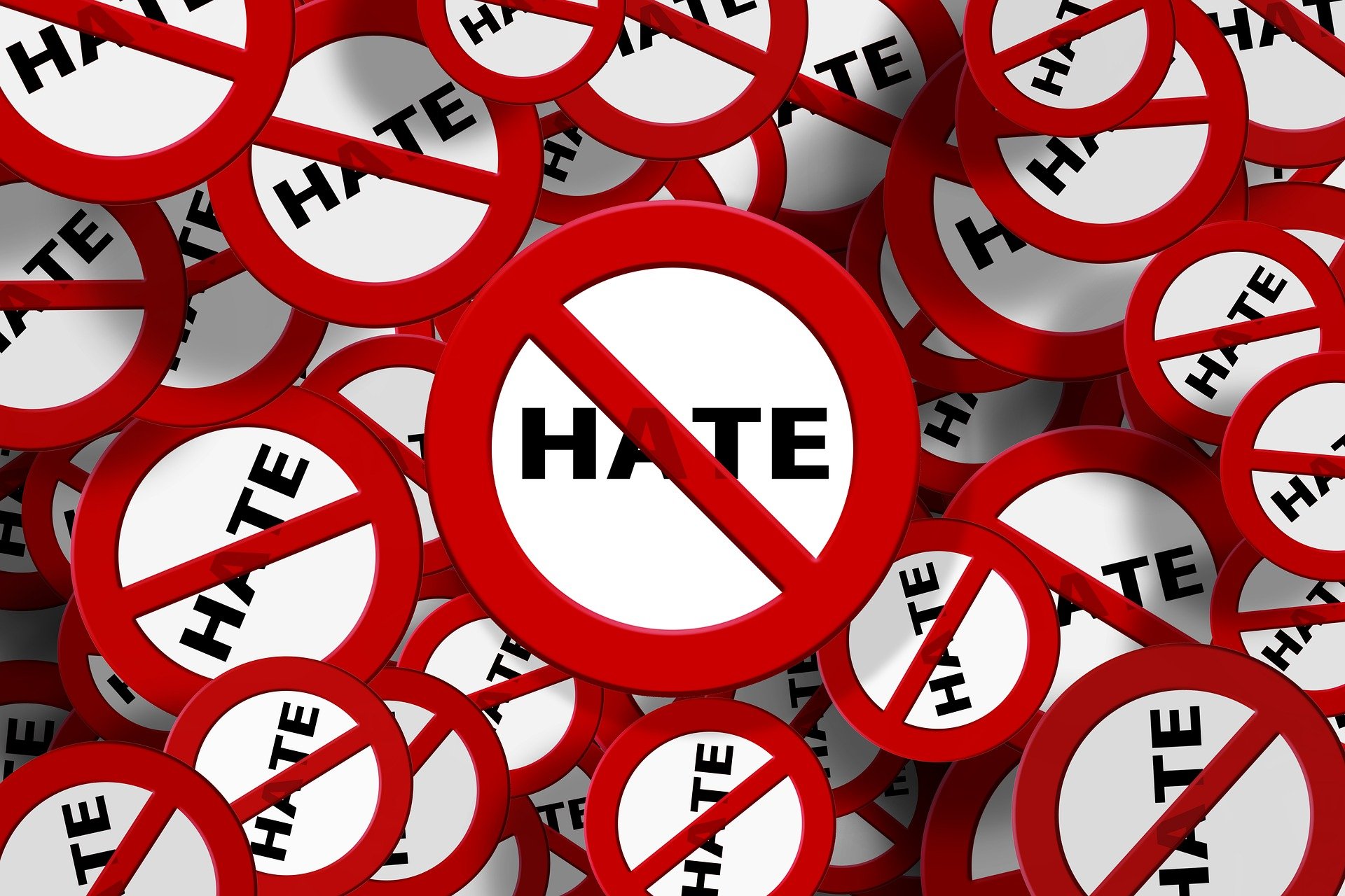 Mehrere rote "No hate"-Symbole überlagern sich und zeigen das Wort "HATE" hinter einem roten Verbotsschild, das eine Anti-Hass-Botschaft vermittelt.
